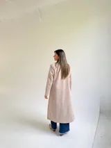 Tapado largo de paño en color beige, con solapas anchas, cierre frontal de un botón y diseño estructurado.