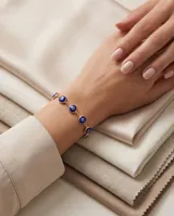 Pulsera de plata 925 con baño de oro y dijes circulares de ojo turco en color azul.