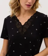 Pijama largo negro de viscolycra con estampa floral, compuesto por una remera de manga corta con escote en V y aplicación de encaje, y un pantalón con cintura elastizada.