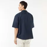 Camisa de manga corta azul marino confeccionada en popelín, con cuello camisero clásico y cierre frontal de botones.