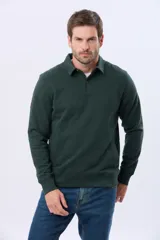 Buzo de felpa color verde oscuro, con cuello tipo polo, cierre frontal parcial con botones y bolsillos laterales. Presenta puños y ruedo acanalados.