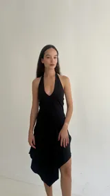 Vestido midi de lycra color negro, con escote halter y diseño asimétrico en el ruedo.