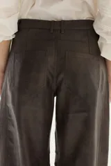 Pantalón de efecto cuero (PU) color gris oscuro/marrón, de tiro medio y calce barrel (pierna ancha y redondeada).