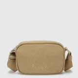 Cartera tipo bandolera de lona color beige, con diseño rectangular, cierre superior y correa ajustable. Presenta el logo de la marca grabado en el centro.