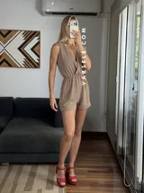 Mono corto negro con escote en V cruzado, sin mangas y con cinturón dorado.