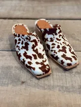 Zuecos con estampado de vaca en tonos marrones y blancos, con punta cuadrada y suela de madera.