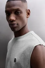 Camiseta sin mangas gris de corte regular fit, con cuello redondo. Presenta un bordado de un guante de boxeo en el pecho y un parche con logo en la parte inferior.