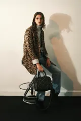 Tapado de corte recto con solapas angostas, cierre frontal con botones y bolsillos ojal. Confeccionado en paño con estampado animal print.