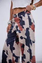 Pantalón de jean de tiro medio-bajo con corte recto y estampado tipo animal print de manchas irregulares en tonos beige, azul oscuro y terracota. Confeccionado en denim rígido sin elastano.