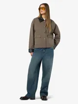 Campera de estilo worker color marrón topo, con cuello camisero y puños en contraste de color negro. Presenta cierre frontal con botones a presión metálicos, dos bolsillos frontales con solapa y diseño de corte holgado.