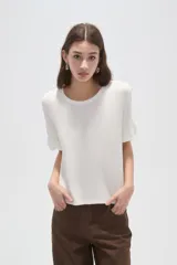 Remera negra de viscosa con textura acanalada, cuello redondo y mangas cortas terminadas en volados.