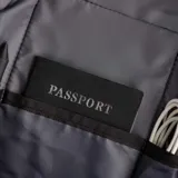 Bandolera negra de poliéster y simil cuero, con diseño ultrafino y ligero. Cuenta con correas reforzadas para uso izquierdo o derecho, bolsillo delantero con velcro, bolsillo trasero antirobo con cierre y espacio para tablets de hasta 7 pulgadas.