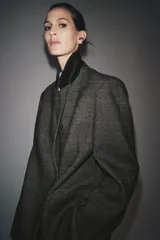 Blazer Zara Woman Collection confeccionada en tejido con lana, de corte oversize. Presenta cuello con solapas de muesca, cierre frontal cruzado con un botón y bolsillos de vivo en el delantero. Incluye forro interior.