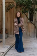 Jeans de corte flare color azul oscuro, tiro alto y diseño ajustado en las piernas que se ensancha gradualmente desde las rodillas hacia el dobladillo.