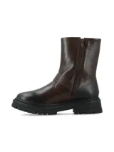 Bota corta de cuero color chocolate con acabado oscurecido, suela track dentada y hebilla metálica lateral decorativa. Cuenta con cierre lateral interno para facilitar el calce.