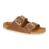 Sandalia Birkenstock modelo Arizona con dos correas anchas de cuero marrón y hebillas grandes doradas. Cuenta con plantilla anatómica de corcho y suela de goma blanca.