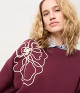 Saco de algodón color bordó con bordado floral en cuerda de color crudo en el frente y las mangas, cuello redondo acanalado, mangas largas y puños ajustados.