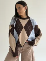 Sweater de punto con diseño de rombos en tonos marrón, beige y celeste, de corte holgado, cuello redondo y manga larga.