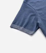 Remera de manga corta color azul con cuello redondo y detalles contrastantes en el ruedo de las mangas y el bajo. La parte delantera es lisa y la espalda presenta un estampado grande con diseño centralizado de elementos marinos.