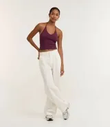 Top cropped de algodón color amarillo pálido, con escote en V pronunciado y tirantes finos que se atan en la nuca (estilo halter). El tejido es acanalado.