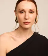 Blusa negra de crepé con un solo hombro, escote drapeado y manga corta.