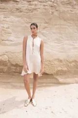 Vestido corto color beige, sin mangas y con cuello redondo.