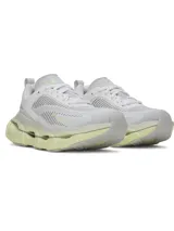 Championes de running Under Armour modelo Halo Racer, color blanco con detalles en amarillo pálido. Presentan una parte superior de malla transpirable, amortiguación UA HOVR+ para retorno de energía y una suela de goma duradera con diseño ergonómico.