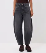 Pantalón de jean color azul oscuro, modelo baggy balloon de tiro medio, con bolsillos funcionales, trabillas en la cintura y recortes laterales que aportan una silueta redondeada.