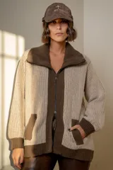 Campera de punto en lambswool, con diseño bicolor en tonos beige y marrón chocolate. Presenta cuello alto, cierre frontal con doble cursor, bolsillos laterales y puños acanalados.