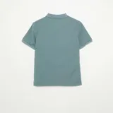 Remera tipo chomba de manga corta con textura de nido de abeja, color azul, cuello polo y cierre frontal parcial de cremallera.