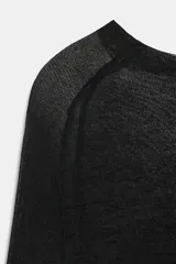 Jersey de punto semitransparente color gris claro, con cuello redondo y manga larga.
