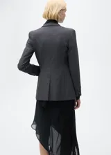 Chaqueta de corte recto con estampado de micro pata de gallo, cuello con solapa y cierre frontal de botones. Presenta mangas largas con puños abotonados, bolsillos delanteros con solapa y abertura posterior en el bajo.