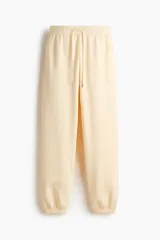 Pantalón deportivo de tiro alto confeccionado en felpa de mezcla de algodón con interior cepillado. Presenta cintura elástica con cordón de ajuste, bolsillos laterales al bies y puños elásticos en los bajos.