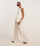 Pantalón wide leg color crudo, con cintura elástica ajustable con cordón y textura.