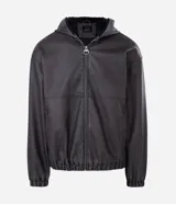 Chaqueta masculina de poliuretano color negro, con diseño de capucha, cierre frontal completo y puños elásticos. Presenta un acabado liso y estructura robusta.