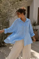 Camisa de lino celeste oversize con bolsillos frontales, botones de nácar y terminaciones desflecadas.