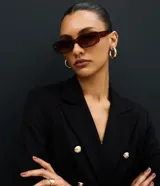 Blazer estructurado de corte cruzado en tejido de Punto Roma, con cuello de solapa, bolsillos con solapa, manga larga y botones metálicos dorados.