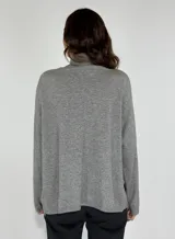 Sweater color beige con cuello alto y detalle de encaje en el frente.