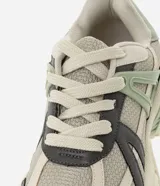 Championes Satinato estilo jogging con suela robusta, capellada de malla gris con recortes en cuero sintético gris oscuro, verde y beige, y cordones blancos.