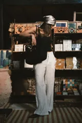 Pantalón de corte recto y tiro alto, confeccionado en lino color blanco. Presenta cierre frontal con botón y bolsillos laterales.