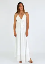 Vestido largo blanco de tirantes finos, con escote en V profundo y detalle de volados en el frente. Diseño fluido y ligero.