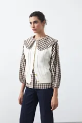 Chaleco tejido de punto color marrón oscuro, con botones frontales y diseño de punto calado vertical.