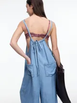Enterito largo de denim suave, color negro, con escote recto, breteles regulables y silueta amplia de pierna recta con caída fluida.
