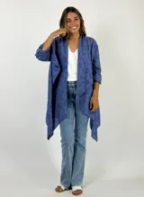 Camisola azul con calados circulares, mangas 3/4 con botón y corte irregular.