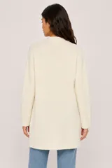 Saco abierto de punto, color beige, con mangas largas y diseño holgado de corte recto.