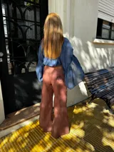 Pantalón sastrero de lino color marrón, de corte recto y tiro alto. Presenta un delicado bordado de un caballo en uno de los bolsillos traseros y costuras en contratono.