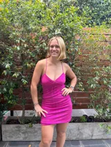 Vestido corto de color verde esmeralda, con escote en pico y breteles finos. Presenta aberturas en los laterales de la cintura y espalda descubierta.