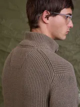 Sweater de punto grueso color azul marino, con cuello alto y cierre frontal de botones.