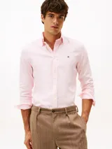 Camisa de corte slim fit, color rosa claro, confeccionada en tejido dobby de algodón elástico. Presenta cuello con botones y puños redondeados con botón.