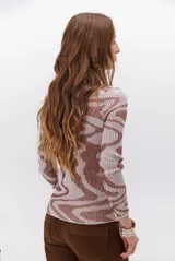 Polera de tejido de punto con diseño vanizado que combina tonos tierra y crema en un patrón abstracto de líneas onduladas. Presenta cuello alto, mangas largas y un ajuste entallado al cuerpo.